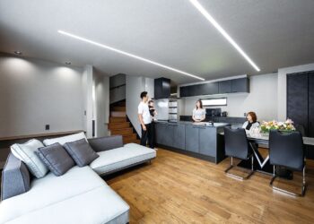 キッチンをはじめ、クロス、インテリア、家電、建具など黒とグレーのモノトーンでまとめられた邸内。地熱床システムだからこそ採用できる『無垢床＋床暖房』の組合せにより、落ち着きと温もりの調和した世界観が可能となった。またアンティーク調の無垢床の色合いもこだわった。